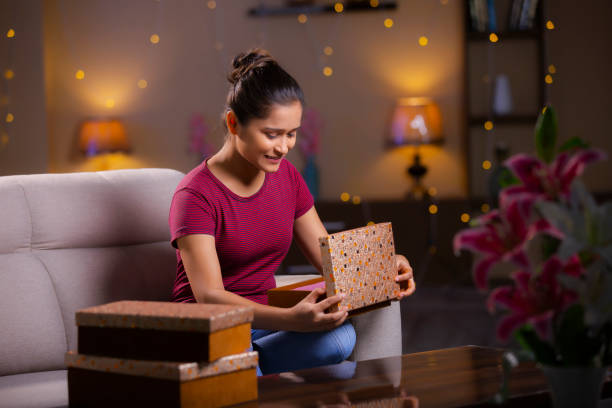 An Indian-american eighteen years old girl opening a gift - gifts for 18 year old girls