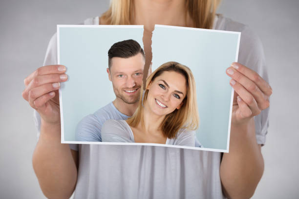 Close-up Of Woman Tearing Photo Of Smiling Couple - gifts for an ex-wife
