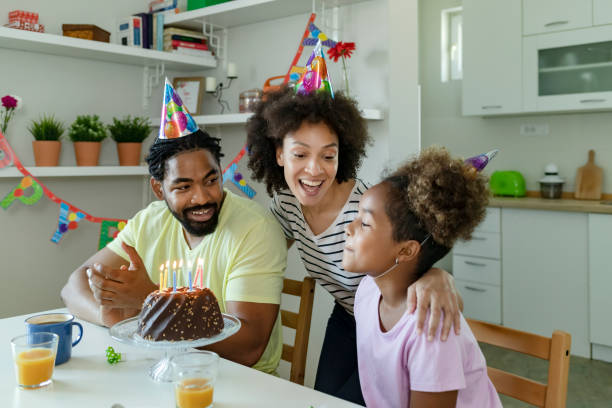 Happy Family is Smiling While Sitting at the Table in Decorated Kitchen During Bonus Daughter Birthday Celebration - bonus daughter gifts