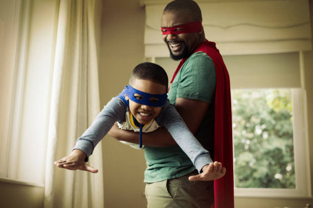Smiling son and father pretending to be a superhero at home - superhero Father's Day gifts