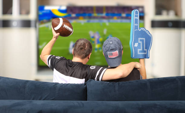 Fans of american football. Father and son watching TV. - dallas cowboys father’s day gifts