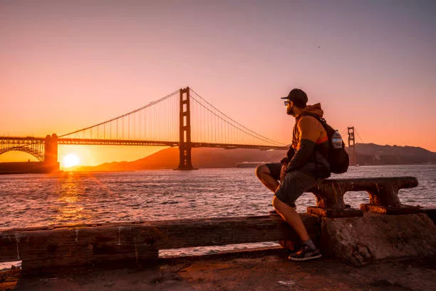 A young man in the red sunset at the Golden Gate in San Francisco. USA - gifts for someone moving to san francisco